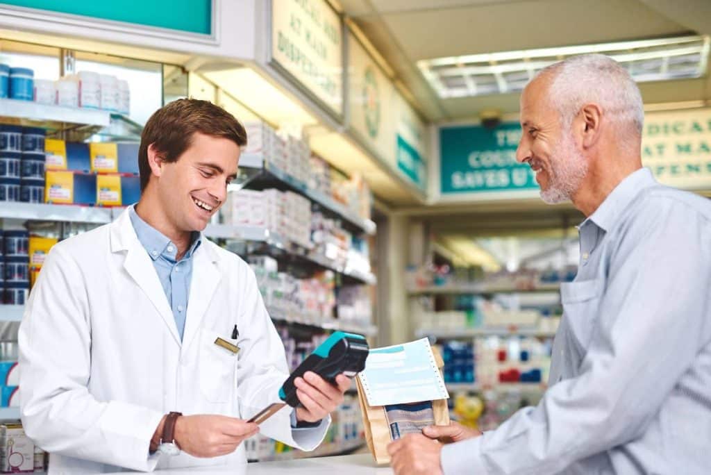 man in pharmacy using hsa card to pay for prescriptions