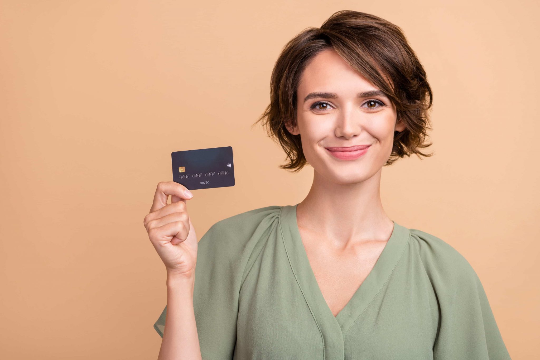 A woman holding a debit card with a BIN number on it 
