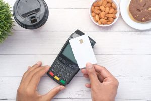 a person holding a debit card next to a calculator